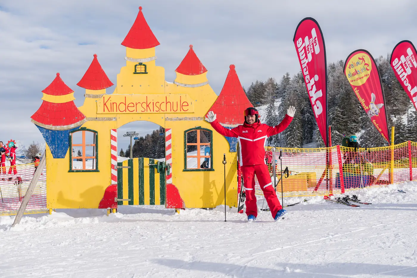 Skilehrerin vor der gelben Burg im Kinderland der Kinderskischule Alpendorf