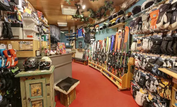 Shop mit Skiverleih in der Gondelstation Alpendorf mit Ski, Helmen und Zubehör